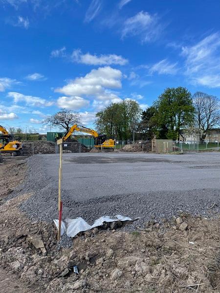 View looking south-west across the gravel plateau that forms the outline of the building and the piling mat. 